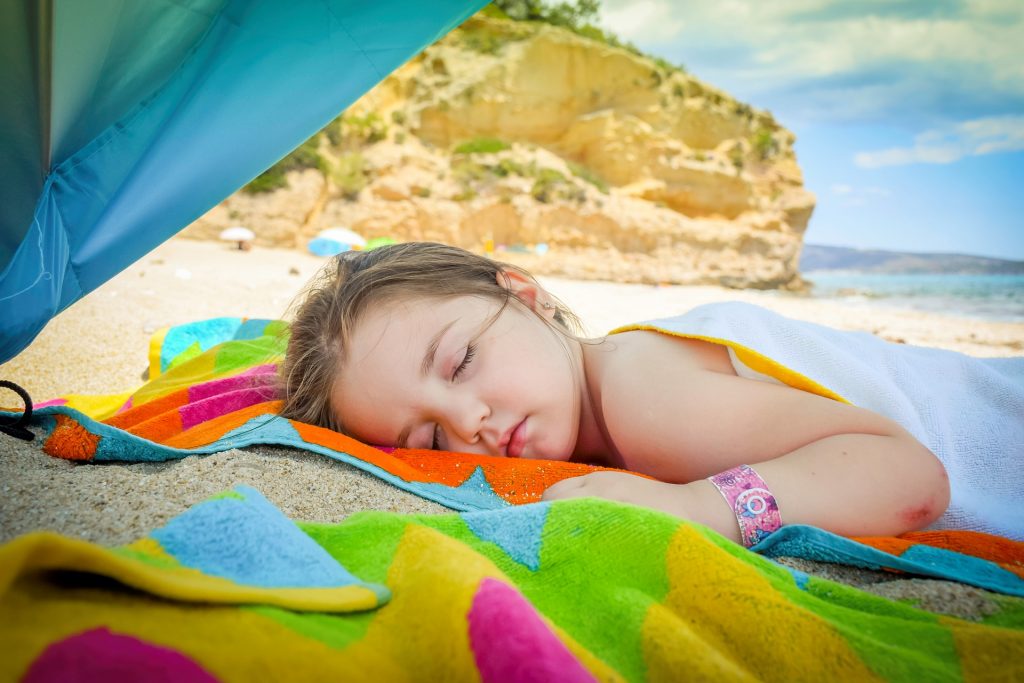 Natürlich ist das Toben am Strand anstrengend. Unterm Sonnenschirm ist dann ein guter Platz für ein Nickerchen.